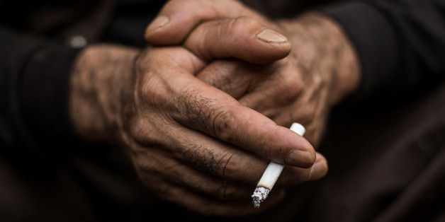 A Kurdish worker smokes a cigarette as he takes a break at a demolition site in Chiba east of Tokyo, October 21, 2015. To match Special Report JAPAN-KURDS/ REUTERS/Thomas Peter