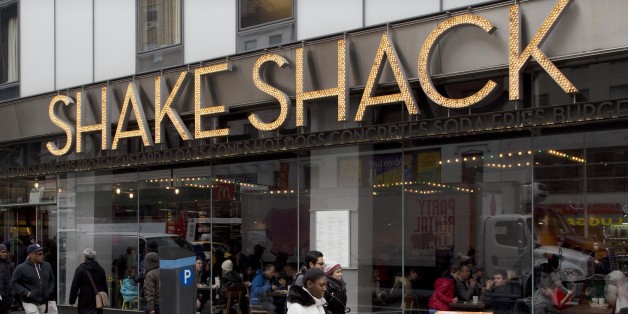 FILE - In this Friday, March 4, 2016, file photo, people walk past a Shake Shack in New York. Shake Shack reports financial results Thursday, May 12, 2016. (AP Photo/Mark Lennihan, File)