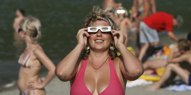 A woman watches an eclipse of the sun in the Altai region, some 300 km (186 miles) from Barnaul , August 1, 2008. A dark shadow swept across Russia on Friday as thousands of skywatchers from all over the world flocked to Siberia to see a rare total eclipse of the sun. REUTERS/Andrei Kasprishin (RUSSIA)