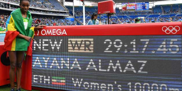Ethiopia's Almaz Ayana celebrates next to a board displaying her new world record after the Women's 10,000m during the athletics event at the Rio 2016 Olympic Games at the Olympic Stadium in Rio de Janeiro on August 12, 2016. / AFP / FRANCK FIFE (Photo credit should read FRANCK FIFE/AFP/Getty Images)