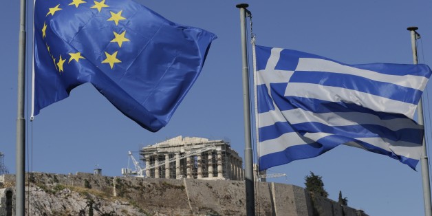 The Greek, right, and the European flags wave under the ancient Acropolis hill in Athens, Sunday, July 5, 2015. Greeks lined up at polling stations and ATMs alike Sunday as the country voted on its financial future, choosing in a referendum whether to accept creditors' demands for more austerity in return for rescue loans or defiantly reject the deal. (AP Photo/Petr David Josek)