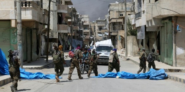 Des membres de forces démocratiques syriennes dans une rue de Minbej en Syrie, le 7 août 2016