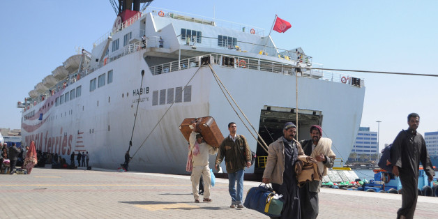 Egyptian workers who fled the unrest in Libya and were stranded in Tunisia, carry their baggage upon their arrival aboard a Tunisian ship in the Mediterranean port city of Alexandria, Egypt Friday, March 4, 2011. (AP Photo/Tarek Fawzy)