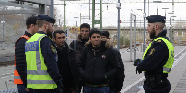 Swedish police officers speak to a group of people at the Hyllie train station near Malmo, Sweden, November 12, 2015. Swedish police began bordering trains on Thursday arriving from Denmark as they imposed the first large-scale border controls in two decades to deal with a refugee influx, but there were no signs the numbers of immigrants were slowing. REUTERS/Staff