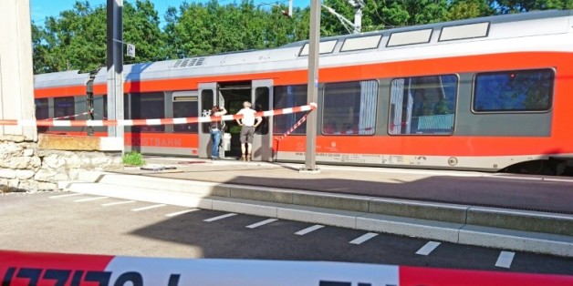 Des policiers aux abords d'un train à la station de Salez (est de la Suisse) après qu'un homme a mis le feu à un wagon et poignardé des passagers, le 13 août 2016