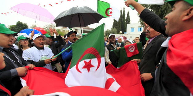 People holding Algerian flags and Tunisian flags march down a boulevard near the Bardo museum, during a ceremonial reopening of the museum in Tunis March 24, 2015. The museum held a ceremonial reopening on Tuesday a week after gunmen claiming alliance with Islamic State killed 20 foreign tourists in an attack aimed at wrecking the country's vital tourism industry. Several thousand Tunisians and foreign visitors to an international forum also marched in the capital Tunis to show solidarity with the Bardo victims who included Japanese, Spanish, Italians and Colombians. REUTERS/Anis Mili