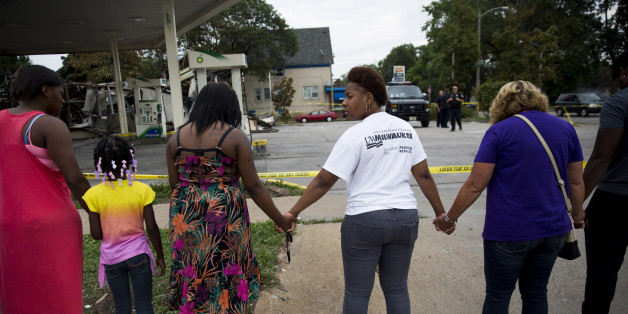 Jasmine Newson, 21, turns around while praying at a gas station that was destroyed by rioters after a fatal police shooting two days prior, on Monday, Aug. 15, 2016, in Milwaukee, Wis. (Armando L. Sanchez/Chicago Tribune/TNS via Getty Images)