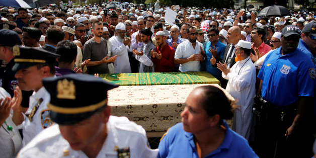 Des hommes prient autour des cercueils contenant les corps d'un imam et de son assistant tués par balles, à New York le 15 août 2016