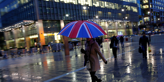 Workers walk in the rain at the Canary Wharf business district in London, Britain November 11, 2013. REUTERS/Eddie Keogh/File Photo