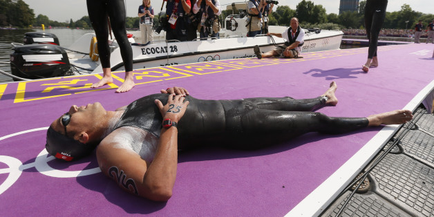 Tunisia's Oussama Mellouli relaxes after winning gold in the men's 10km marathon swimming at Hyde Park during the London Olympic Games August 10, 2012. REUTERS/Stefan Wermuth (BRITAIN - Tags: OLYMPICS SPORT SWIMMING)