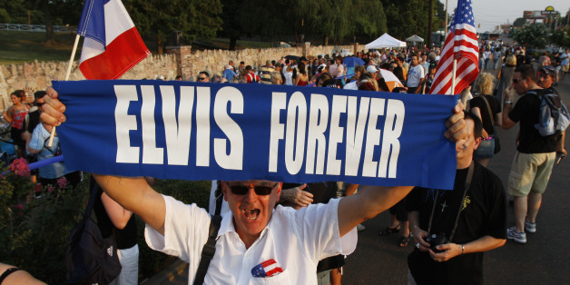 Elvis Presley fan Orlando Bruno of Paris, France holds up his sign as he waits in line to visit Presley's gravesite on the eve of the 30th anniversary of Presley's death, 15 August 2007 at Graceland, Presley's home in Memphis, Tennessee. Fans are gathering to mark the 30th anniversary of the entertainers death on 16 August. AFP PHOTO/Stan HONDA (Photo credit should read STAN HONDA/AFP/Getty Images)