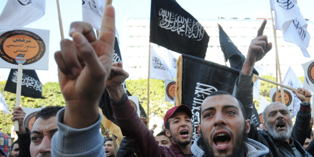 Tunisian protesters shoot slogans during a demonstration called by the supporters of radical Islamist party Hizb ut-Tahrir to protest against the draft Constitution that they consider 'secular' on January 24, 2014 in Habib Bourguiba Avenue in Tunis. Tunisian lawmakers are to vote on January 25, 2014 adopting a long-delayed new constitution, seen as crucial to getting the democratic transition back on track more than three years after the revolution. AFP PHOTO / FETHI BELAID (Photo credit should read FETHI BELAID/AFP/Getty Images)