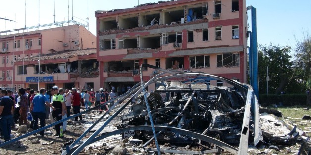 Turkish authorities search outside the damaged building of the police headquarters after an explosion in Elazig, eastern Turkey, on Thursday, Aug. 18, 2016. Two car bombings targeted police stations in Turkey, killing a number of people and wounding hundreds, officials said Thursday. Turkish authorities have banned distribution of images relating to the Elazig explosion within Turkey. (Sahismail Gezici/DHA via AP)