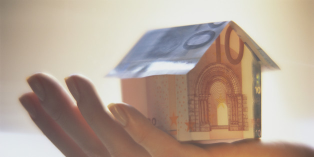 Hand Holding Paper House Made of Euro Notes