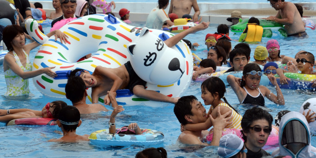 Visitors beat the summer heat at the Yomiuri Land Water Amusement Island (WAI) in Tokyo on July 14, 2013. More than 10,000 visitors enjoy the hot summer weekend at the swimming pools as the temperatures approached 35 degrees celsius in Tokyo. AFP PHOTO / TOSHIFUMI KITAMURA (Photo credit should read TOSHIFUMI KITAMURA/AFP/Getty Images)