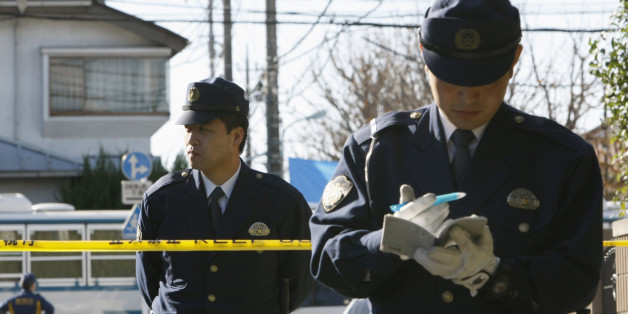 Policemen stand guard at a police line near the house where the wife of a former vice health minister was stabbed, in Tokyo November 19, 2008. The suspected murder of a former vice health minister and the stabbing of the wife of another, both with careers tied to Japan's ailing pension system, prompted Japanese police to tighten security for officials on Wednesday. REUTERS/Kim Kyung-Hoon (JAPAN)