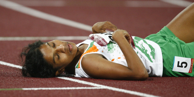 India's Jaisha Orchatteri Puthiya Veetil lies on the track after the women's 5000m final at the 15th Asian Games in Doha December 11, 2006. Veetil took the bronze medal. REUTERS/Jerry Lampen (QATAR)