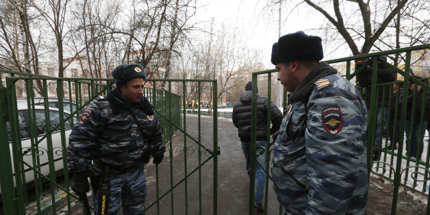 Interior Ministry members stand guard outside the premises of a high school, where a student shot a teacher and a police officer dead and held more than 20 other students hostage, on the outskirts of Moscow, February 3, 2014. The student was later disarmed and detained, police said, just days before Russia hosts the Winter Olympics. REUTERS/Maxim Shemetov (RUSSIA - Tags: CRIME LAW EDUCATION)