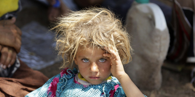 A girl from the minority Yazidi sect, fleeing the violence in the Iraqi town of Sinjar, rests at the Iraqi-Syrian border crossing in Fishkhabour, Dohuk province August 13, 2014. REUTERS/Youssef Boudlal (IRAQ - Tags: CIVIL UNREST POLITICS TPX IMAGES OF THE DAY)