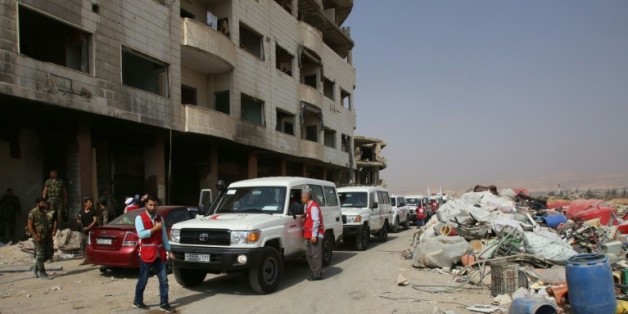 Des ambulances du Croissant rouge escortés par des soldats de l'armée syrienne dans la ville rebelle de Daraya, le 26 août 2016