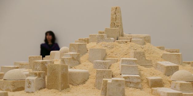 A visitor stands in front of the artwork 'Untitled' (Gharda'a), by Kader Attia, an Algerian city made out of crumbling couscous, in the new Switch House extension of the Tate Modern in London on June 14, 2016. / AFP / Daniel Leal-Olivas / RESTRICTED TO EDITORIAL USE - MANDATORY MENTION OF THE ARTIST UPON PUBLICATION - TO ILLUSTRATE THE EVENT AS SPECIFIED IN THE CAPTION (Photo credit should read DANIEL LEAL-OLIVAS/AFP/Getty Images)