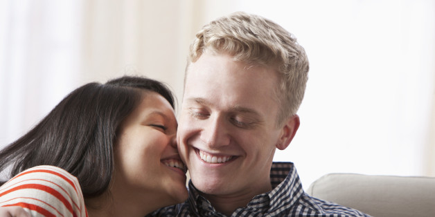 Smiling couple hugging on sofa