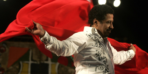 Algerian singer Cheb Khaled covers himself with a Moroccan flag during his concert at the annual Gnaoua Music Festival in Essaouira June 28, 2009. The festival features a mixture of traditional Moroccan and world music, and dancers sometimes go into a trance. REUTERS/Rafael Marchante (MOROCCO SOCIETY ENTERTAINMENT)