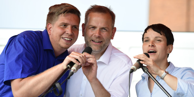 Leif-Erik Holm, Frauke Petry (r) und Lars Loewe (l) singen auf einer Veranstaltung in Wismar die Nationalhymne