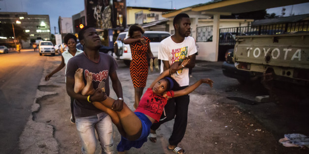 A relative a man detained during clashes is carried to the hospital after she fainted on September 1, 2016 in Libreville