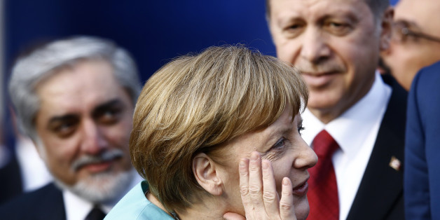 German Chancellor Angela Merkel (C) reacts next to Afghanistan's Chief Executive Abdullah Abdullah (L) and Turkey's President Tayyip Erdogan as they observe a fly past during the NATO Summit in Warsaw, Poland July 8, 2016. REUTERS/Kacper Pempel