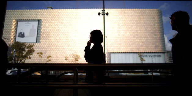 A woman is silhouetted against a department store at Apgujeong luxury shopping district in Seoul, South Korea, November 12, 2015. South Korea's central bank left interest rates at a record low 1.5 percent for a fifth consecutive month, and countered calls for a cut arguing that strong domestic demand could still lead economic recovery despite weak exports.REUTERS/Kim Hong-Ji