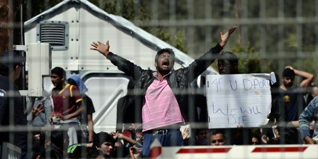Pakistani and Afghan migrants protest inside the Moria detention center against the deportation to Turkey, in Mytilene on April 5, 2016. Migrants return from Greece to Turkey begun on April 4 under the terms of an EU deal that has worried aid groups, as Athens struggles to manage the overload of desperate people on its soil. Over 51,000 refugees and migrants seeking to reach northern Europe are stuck in Greece, after Balkan states sealed their borders. Hundreds more continue to land on the Greek