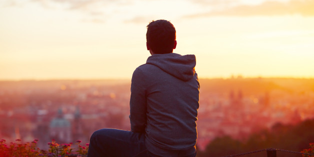 Young man is looking at the sunrise
