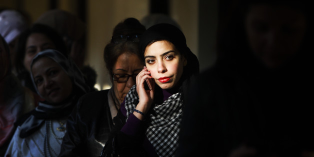 An Egyptian woman talks on her mobile phone while waiting to to vote in Maadi, a suburb of Cairo, Egypt, Monday, Nov. 28, 2011. Voting began on Monday in Egypt's first parliamentary elections since longtime authoritarian leader Hosni Mubarak was ousted in a popular uprising nine months ago. The vote is a milestone many Egyptians hope will usher in a democratic age after decades of dictatorship. (AP Photo/Tara Todras-Whitehill)