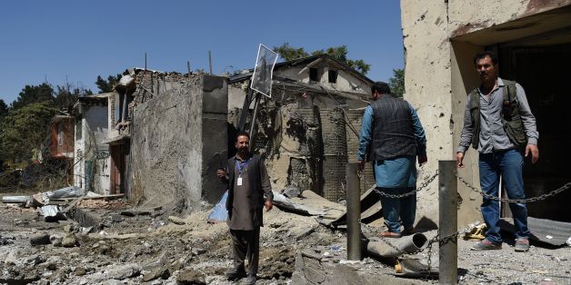 Afghan security personnel and residents walk at the site of a car bomb blast that targeted the CARE International compound at Shar-e-Naw in Kabul on September 6, 2016.Explosions rang out during an hours-long attack on an international charity in Kabul, the latest assault in a wave of violence in the Afghan capital that has killed at least 24 people and wounded dozens. / AFP / WAKIL KOHSAR (Photo credit should read WAKIL KOHSAR/AFP/Getty Images)