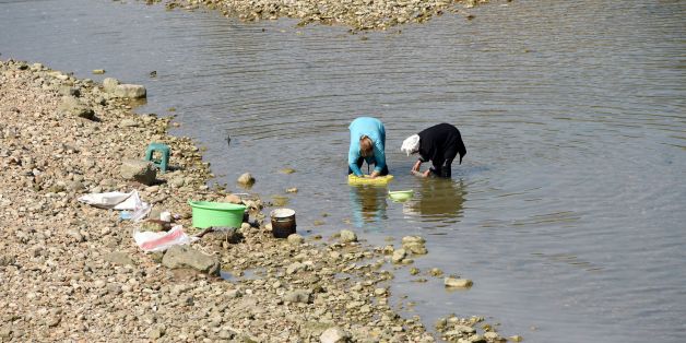 Tunisian women wash wool in the Medjerda River (also written Majerda), whose water level is low due to low rainfall, on August 21, 2016 in the small town of Testour, located in the north of Tunisia in the Beja province. / AFP / FETHI BELAID (Photo credit should read FETHI BELAID/AFP/Getty Images)
