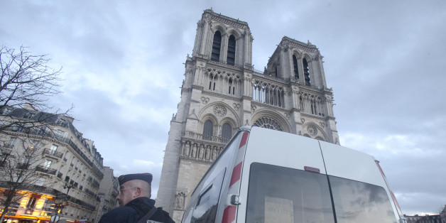 A French Police stand in front of Notre Dame cathedral, in Paris, Thursday, Dec. 25, 2015. France's interior minister Bernard Cazeneuve announced Tuesday that churches will keep only one door open, instead of multiple doors, "to have better filtering at the entrance." (AP Photo/Jacques Brinon)