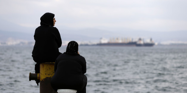 Two women sit on a dock of a refugee camp which houses about 3,200 refugees and migrants, in the western Athens' suburb of Skaramagas, Thursday, Aug. 25, 2016. Numbers arriving in Greece have dropped dramatically since the March agreement with Turkey, but over 58,000 people remain stranded in the country, most in army-built camps on the mainland and over 9,000 refugees are receiving hotel vouchers or live in vacant apartments. (AP Photo/Thanassis Stavrakis)