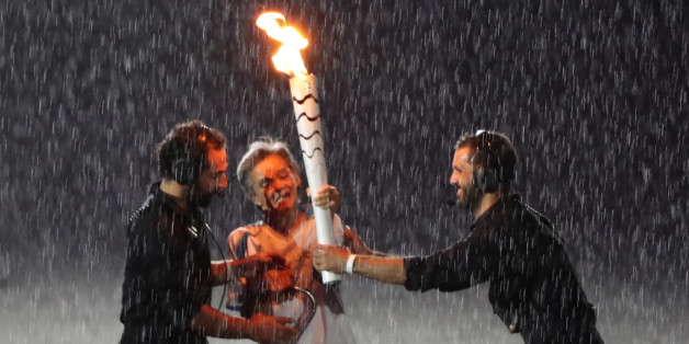 2016 Rio Paralympics - Opening ceremony - Maracana - Rio de Janeiro, Brazil - 07/09/2016. Brazilian Paralympic runner Marcia Malsar is assisted after falling while carrying the torch as rain falls during the opening ceremony. REUTERS/Ueslei Marcelino FOR EDITORIAL USE ONLY. NOT FOR SALE FOR MARKETING OR ADVERTISING CAMPAIGNS.