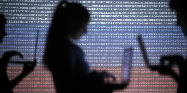People are silhouetted as they pose with laptops in front of a screen projected with binary code and a Russian national flag, in this picture illustration taken in Zenica October 29, 2014. REUTERS/Dado Ruvic (BOSNIA AND HERZEGOVINA - Tags: SCIENCE TECHNOLOGY)
