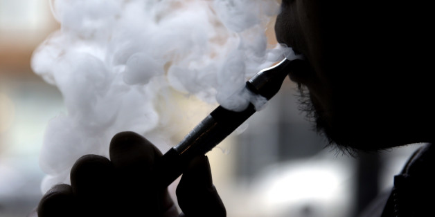 FILE - In this April 23, 2014, file photo, a man smokes an electronic cigarette in Chicago. On Thursday, May 5, 2016, the Food and Drug Administration released long-awaited rules that bring the burgeoning electronic cigarette industry under federal oversight. (AP Photo/Nam Y. Huh, File)