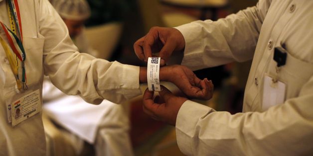 A Saudi official adjusts an electronic bracelet that Saudi authorities are giving to pilgrims ahead of the annual Hajj Muslim pilgrimage in the holy city of Mecca on September 8, 2016. Close to 1.5 million Muslims from around the world had descended on Saudi Arabia for the annual hajj pilgrimage, undeterred by last year's stampede disaster but with Iranians absent. / AFP / AHMAD GHARABLI (Photo credit should read AHMAD GHARABLI/AFP/Getty Images)