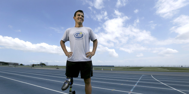 In this May 7, 2013, photo, Mohamed Lahna, a 2016 Paralympic hopeful in the triathlon, poses for a photograph on the College of San Mateo track in San Mateo, Calif. A para-triathlete for all of five years, the 31-year-old native of Morocco has his sights set on the 2016 Paralympics in Rio de Janeiro. Born without a femur in his right leg, Lahna has a tiny foot at about knee level that fits into a prosthetic that goes all the way up to his glute. (AP Photo/Jeff Chiu)