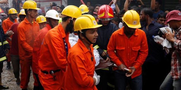 Rescue team members remove a dead body at a food and cigarette packaging factory after a fire broke out outside of Dhaka, Bangladesh, September 10, 2016. REUTERS/Mohammad Ponir Hossain