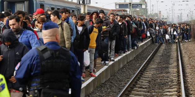 A Hungarian police officer watches as migrants arrive at the train station in Hegyeshalom, Hungary, October 6, 2015. Austria and Germany have committed to backing Greek efforts to secure more EU funds to cope with the influx and to boost staff on the ground. Many of the almost 400,000 migrants who have arrived in Greece this year have later passed through Austria on their way to Germany. REUTERS/Leonhard Foeger