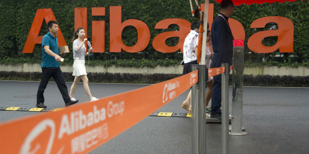 FILE - In this Friday, May 27, 2016, file photo, staffers pass security guards near a company logo at the Alibaba Group headquarters in Hangzhou, in eastern China's Zhejiang province. Alibaba reports financial results Thursday, Aug. 11. (AP Photo/Ng Han Guan, File)