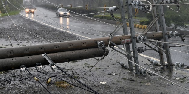 Cars drive past collapsed power lines, that partially block the road, as super typhoon Meranti skirts Pingtung county in southern Taiwan on September 14, 2016.Parts of Taiwan were brought to a standstill on September 14 as the strongest typhoon of the year skirted past the island's southern tip, knocking out power for more than 180,000 households. / AFP / SAM YEH (Photo credit should read SAM YEH/AFP/Getty Images)