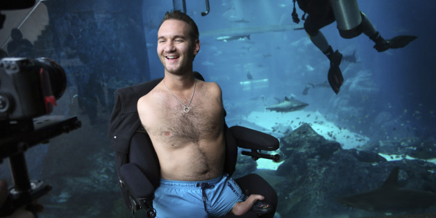 Nick Vujicic poses for his camera crew before diving with sharks Thursday, Sept. 5, 2013 in Singapore. Vujicic, a Serbian Australian evangelist and motivational speaker born with tetra-amelia syndrome, a rare disorder characterized by the absence of all four limbs, is in the city-state to give a motivational talk and was visiting "The Shark Encounter at Marine Life Park" at one of Singapore's main tourist attractions in Resorts World Sentosa. (AP Photo/Wong Maye-E)