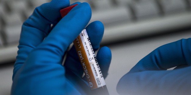 An employee of the Russia's national drug-testing laboratory holds a vial in Moscow, Russia, Tuesday, May 24, 2016. The Russians have been accused of state-sponsored doping at the 2014 Sochi Olympics, and the IOC has asked WADA to carry out a full-fledged investigation and plans to retest Sochi samples. (AP Photo/Alexander Zemlianichenko)