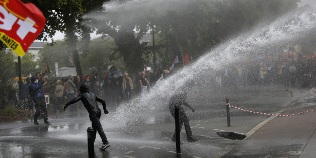 Demonstrators are sprayed by a water canon during clashes with French riot police at a march in Nantes, western France, to demonstrate against the new French labour law, September 15, 2016. REUTERS/Stephane Mahe